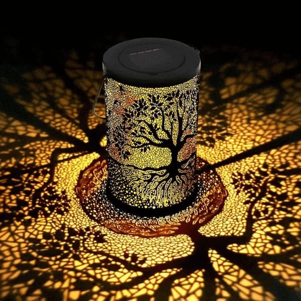 3D solar tree of life lantern casting warm amber shadow patterns across a table — view 2