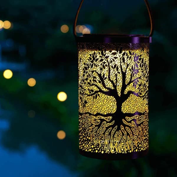 3D solar tree of life lantern casting warm amber shadow patterns across a table — view 3