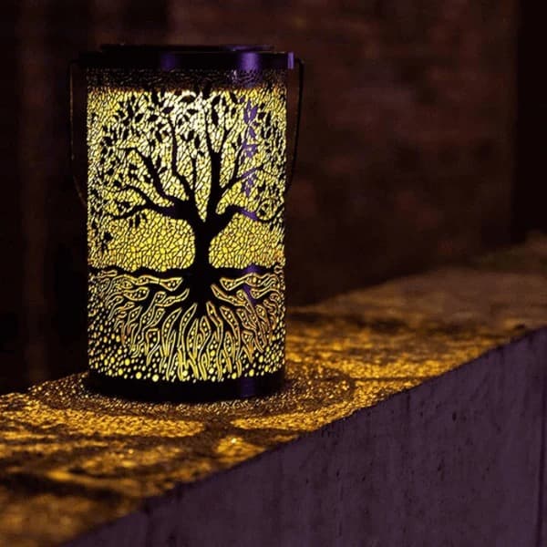 3D solar tree of life lantern casting warm amber shadow patterns across a table — view 4