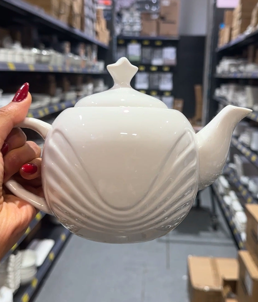 White ceramic teapot with elegant curved embossed design, ideal for serving tea or coffee, displayed on store shelf