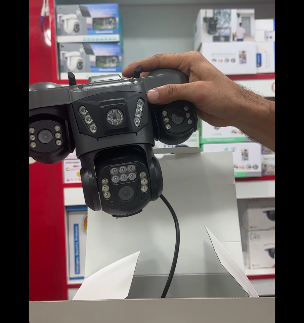 360-degree outdoor Wi-Fi security camera with four lenses, night vision, and motion detection floodlights mounted on a wall.
