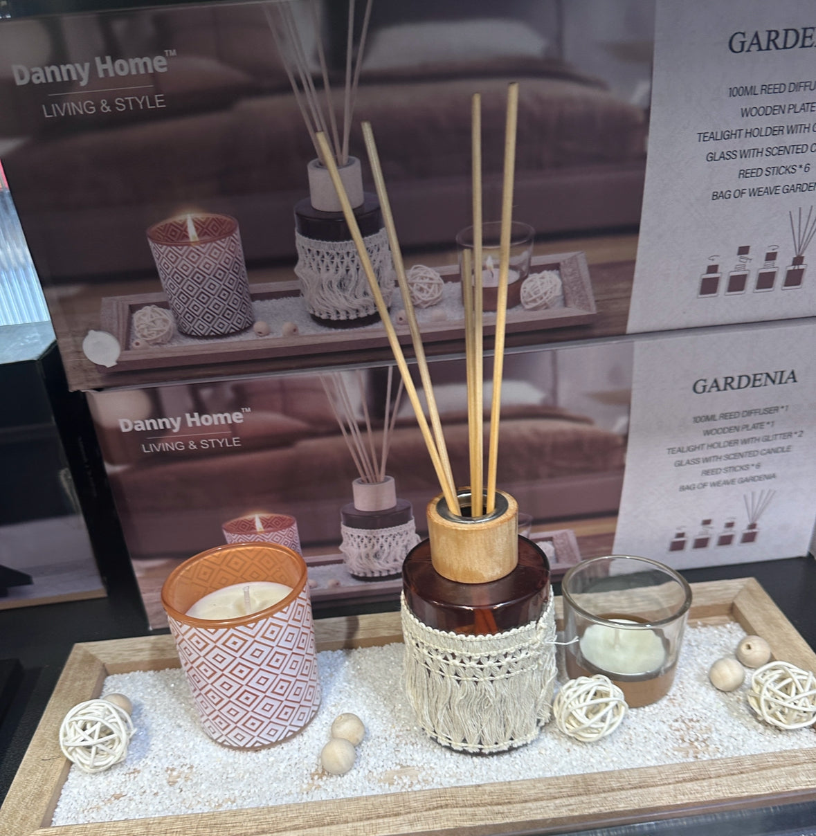 Danny Home Gardenia reed diffuser and candle set displayed on a wooden tray with decorative accents.
