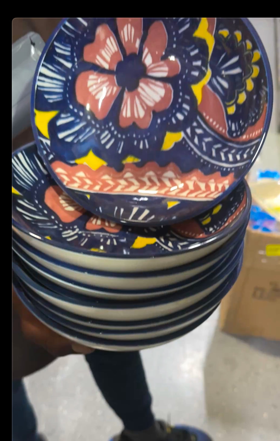Blue floral hand-painted ceramic side plate with navy and coral design stacked on display