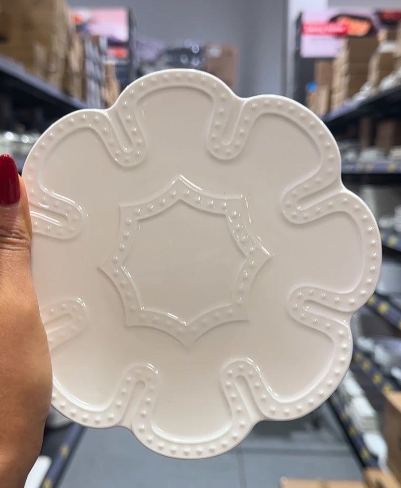 White scalloped ceramic saucer with embossed petal edge, ideal for teacups or desserts.