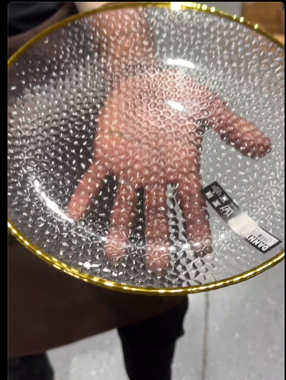 Clear textured glass plate with a gold rim, reflecting light for an elegant dining look